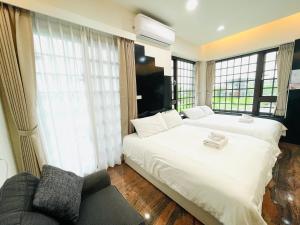 una camera da letto con un grande letto bianco e un divano di 宜蘭包棟民宿 安娜貝絲 獨棟l KTV唱到飽l電動麻將l全套廚房l看電影l遊戲機l 烤肉BBQ l國旅卡特約 a Wujie