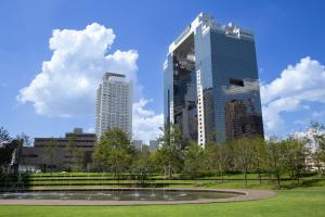 two tall buildings in a park with a fountain at The Westin Osaka in Osaka