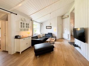 a living room with a couch and a tv at Strandblick - Dorf 1 Ferienhaus 13 in Priwall