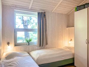 a bedroom with two beds and a window at Strandblick - Dorf 1 Ferienhaus 21 in Priwall +61 photos
