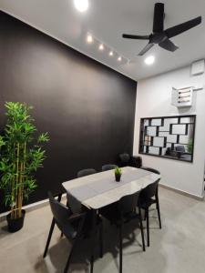 a dining room with a table and chairs and a ceiling fan at Sam Choon Homestay 三春客棧 Batu Pahat City Centre 4R4B4CP 峇株巴轄民宿 市中心Summit旁邊 四房四浴停車方便 in Batu Pahat