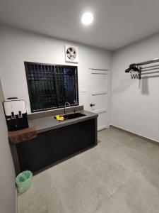 an empty kitchen with a sink and a window at Sam Choon Homestay 三春客棧 Batu Pahat City Centre 4R4B4CP 峇株巴轄民宿 市中心Summit旁邊 四房四浴停車方便 in Batu Pahat +6 photos