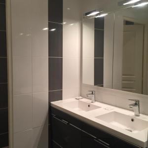 a bathroom with two sinks and a large mirror at Hôtel Allety in Paris