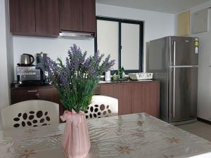 a kitchen with a table with a vase with purple flowers at Landmark Lovely Coast View King Suite#500mbpsWifi#Netflix in Tanjong Tokong