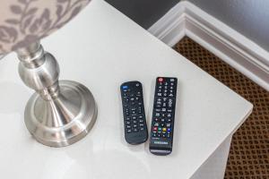 two remote controls sitting on a white table at Gold Crest Guesthouse in Roodepoort