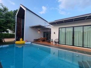a swimming pool in front of a house at Starry Night Pool Villa Khaoyai in Wangkata