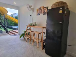a kitchen with a black refrigerator and a table at Starry Night Pool Villa Khaoyai in Wangkata
