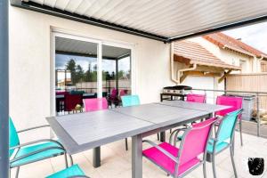 a dining table and chairs on a patio at maison avec piscine chaufée couverte d'avril à fin octobre in Ranville