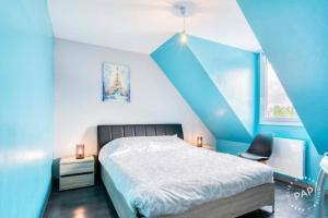 a blue bedroom with a bed and a chair at maison avec piscine chaufée couverte d'avril à fin octobre in Ranville +9 photos