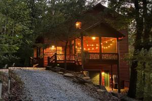a log cabin with a porch and lights on it at Tree Top Hideaway - Private with Games Firepit More in Blue Ridge