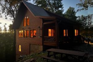 a log cabin with its door open in the forest at Tree Top Hideaway - Private with Games Firepit More in Blue Ridge