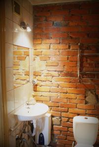 a bathroom with a white sink and a brick wall at Kasienka Cottage in Stronie Śląskie