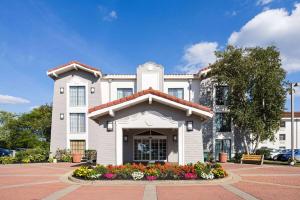 a large white building with flowers in front of it at La Quinta Inn by Wyndham Pittsburgh Airport in Moon Township