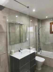 a bathroom with a sink and a toilet and a mirror at Casa Terria in Tías