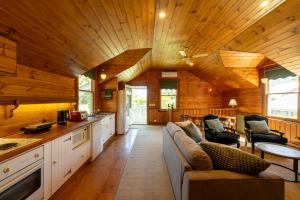 a kitchen and living room with a couch in a cabin at Craignair Cottage in Mount Macedon