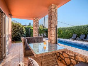 マリンスカにあるVilla Badiのテーブルと椅子とプールのあるパティオ