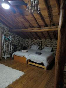ein Schlafzimmer mit einem Bett in einem Steingebäude in der Unterkunft Agroturismo Los Prados Sierra de San Vicente in Castillo de Bayuela