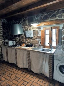 eine Steinküche mit Spüle und Herd in der Unterkunft Agroturismo Los Prados Sierra de San Vicente in Castillo de Bayuela + 5 Fotos
