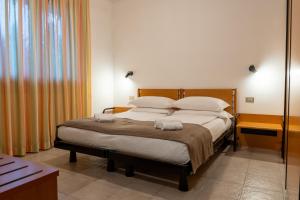 a bedroom with a bed with two towels on it at Hotel Costaverde "ai Roni" in Andalo