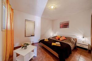 a small bedroom with a bed and a table at Pool House Potirna - Happy Rentals in Blato