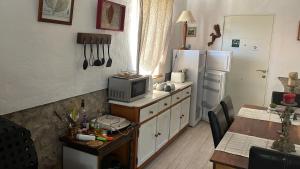 a kitchen with a table with a microwave and a refrigerator at Casa Tatisita Buhardilla in Segura de la Sierra