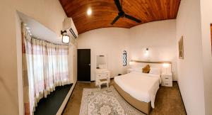 a bedroom with a white bed and a wooden ceiling at Eden villa colombo in Kirillapone