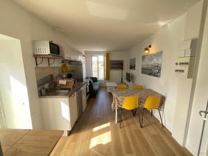 a kitchen and dining room with a table and yellow chairs at "Gîte les fûtreaux" vue sur Loire & linge inclus in Blois