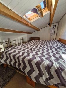 a bedroom with a large bed in an attic at Pavillon proche plage in Narbonne