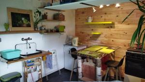 a kitchen with a counter and a table in it at Tiny House cosy, jardin romantique forestier, route du vin, sentiers in Lalaye