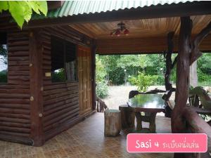 Holzhütte mit einem Tisch und einer Terrasse in der Unterkunft ศศิคันทรี รีสอร์ท in Suan Phung + 139 Fotos