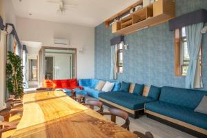 a living room with a blue couch and a table at La Casa Panacea Okinawa Resort in Onna