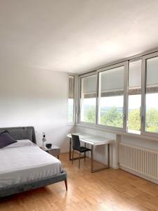 a bedroom with a bed and a desk and windows at Nuovo Progetto A&E in Vicenza +9 photos