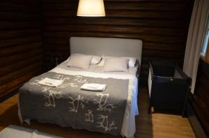 a bedroom with a bed with two towels on it at Secret Lapland - Luxury Villa Siida with Northern Lights Hut in Pyhätunturi