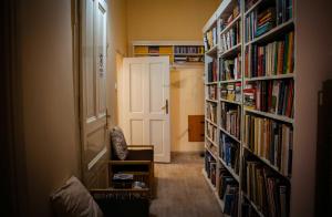a hallway with book shelves filled with books at Csengőd Kúria in Csengőd