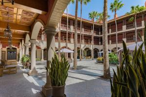 a courtyard with palm trees and a building at Elba Palace Golf Boutique Hotel - Adults Only in Caleta De Fuste
