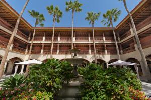 a building with palm trees and a fountain at Elba Palace Golf Boutique Hotel - Adults Only in Caleta De Fuste +19 photos