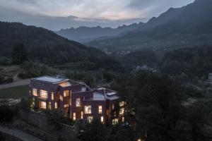 兴隆Vretreats Suyunjian Boutique Hotel的山上的房屋,灯火通明