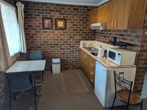 a small kitchen with a counter and a microwave at Barham Colonial Motel in Barham