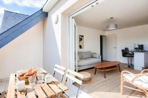 a living room with a table and a couch at Centre-ville Pléneuf Val André, appartement pour 4 in Pléneuf-Val-André