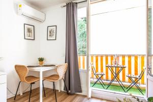 a dining room with a table and chairs and a balcony at Le landella in Menton