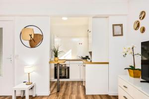 a kitchen with white cabinets and a table with a lamp at Le landella in Menton +6 photos