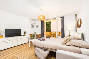 a bedroom with two beds and a television in it at Le landella in Menton