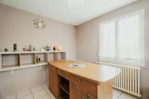a kitchen with a wooden table and a window at Charmante maison néo-bretonne in Plumaudan +13 photos