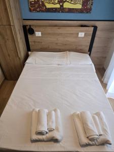 a bed with two towels and two slippers on it at Hotel BluMarine in Roseto degli Abruzzi