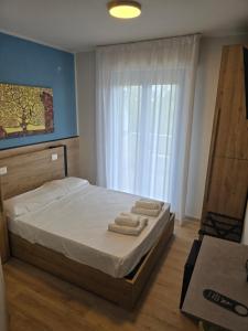 a bedroom with a bed with two towels on it at Hotel BluMarine in Roseto degli Abruzzi