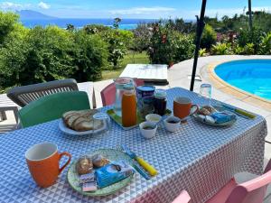 a table with breakfast food on it next to a pool at Pink Bliss in Avae