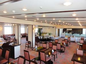 a dining room with tables and chairs and a restaurant at Kushiro Royal Inn in Kushiro