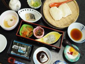 a table with bowls of food and cups of tea at Hotel Himakasou in Minamichita