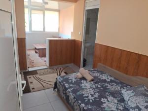 a small bedroom with a bed and a shower at Къща за гости Релиса in Razgrad
