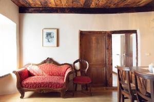 a living room with a chair and a table at Antica Casa Noce Rivoria in Masera